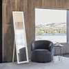 A modern living room with a large window overlooking a landscape, featuring a standing mirror, a swivel chair, and a side table. Náhľad obrázku produktu