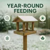A wooden bird feeder with snow on its roof, surrounded by icons representing the four seasons, with text indicating year-round feeding. Anteprima dell’immagine prodotto