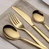 A set of gold-colored cutlery is laid out on a checkered cloth. Anteprima dell’immagine prodotto