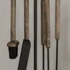 Close-up view of a fireplace tool set with wooden handles and metal components. Anteprima dell’immagine prodotto
