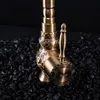 A close-up shot of a bronze-colored faucet with intricate carvings, resting on a bed of black stones. Podgląd zdjęcia produktu