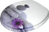 A toilet seat with a decorative design of stones and a purple flower. Produktbild-Vorschau