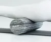 A close-up shot of a person's leg resting on a foam roller. Produktbild-Vorschau