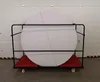 A round folding table on a cart in front of a garage door. Produktbild-Vorschau