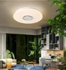A modern living room with a large window overlooking a forest, featuring a ceiling light, sofa, coffee table, and a desk. Produktbild-Vorschau