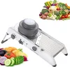 A mandoline slicer is shown in the foreground, with a pile of fresh vegetables in the background. Produktbild-Vorschau