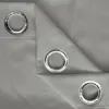 A close-up view of a gray fabric curtain with grommets. Náhled obrázku produktu