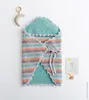 A crocheted baby swaddle with a wooden toy and a milestone card. Produktbild-Vorschau