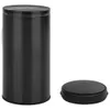 A black cylindrical trash can with its lid placed next to it on a white background. Produktbild-Vorschau