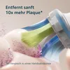 Close-up of a toothbrush head with bristles and pink particles, suggesting plaque removal. Podgląd zdjęcia produktu