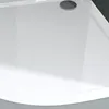 A close-up view of a white shower tray with a drain. Produktbild-Vorschau