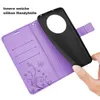 A hand is holding a black phone case over an open purple wallet case with card slots and a floral design. Produktbild-Vorschau