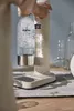 A person is using a sand-colored Aarke water carbonator with a clear bottle filled with bubbly water. Produktbild-Vorschau