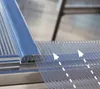A close-up view of a clear, ribbed material being attached to a silver aluminum frame. Produktbild-Vorschau