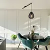 A dining room with a round table and chairs, a pendant lamp, and wall paneling. Produktbild-Vorschau