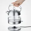 A person holding a kettle over its base against a white background. Produktbild-Vorschau