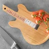A wooden cutting board shaped like a guitar, with tomatoes and a knife on it. Náhľad obrázku produktu