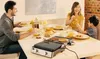 A family enjoying breakfast together around a table, with a grill in the foreground. Podgląd zdjęcia produktu
