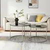 Two round coffee tables are placed in front of a sofa in a living room setting. The tables have black marble tops and silver metal legs. A vase with greenery, a cup of coffee, and a bowl are on the tables. Pillows in black and yellow are on the sofa. Voir les images du produit