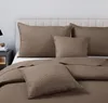 A close-up view of a bed with brown quilted bedding and pillows. Produktbild-Vorschau