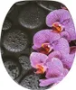 A close-up of a toilet seat with a pattern of purple orchids and black stones with water droplets. Produktbild-Vorschau