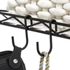 A close-up view of black S-hooks hanging from a black wire shelf, with a woven white basket in the background and two items hanging from the hooks. Produktbild-Vorschau