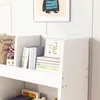 A close-up of a white bookshelf filled with books and decorative items. Náhľad obrázku produktu