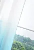 A close-up view of a curtain with a turquoise gradient, seen through a window with a view of green trees. Produktbild-Vorschau