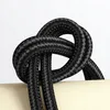 A close-up shot of a black braided USB-C cable tied in a knot. Produktbild-Vorschau