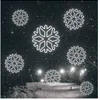 Snowflakes are superimposed over a nighttime ski slope with lights and people. Podgląd zdjęcia produktu