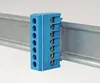 A blue terminal block is mounted on a metal DIN rail. Produktbild-Vorschau