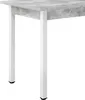A close-up view of the corner of a table with a concrete-look tabletop and white legs. Anteprima dell’immagine prodotto