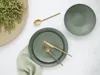 A table setting with plates, cutlery, and a napkin, along with a decorative element of dried grass. Náhľad obrázku produktu