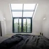 A bedroom with a large skylight window and a bed. Náhľad obrázku produktu