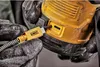 Hands wearing black gloves are plugging a yellow USB-C cable with a DeWalt logo into a yellow and black DeWalt DCR009-XJ Bluetooth speaker battery. Podgląd zdjęcia produktu