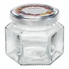A hexagonal glass jar with a silver lid and a decorative label featuring fruits. Voir les images du produit