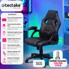 A gaming chair with feature callouts and branding, set in a room with a computer setup. Náhled obrázku produktu