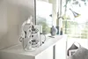 A white controller and headset holder stand on a white dresser next to a television. Produktbild-Vorschau