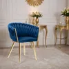 A blue velvet chair with gold legs in a luxurious room setting. Náhled obrázku produktu