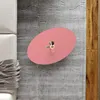 A pink oval coffee table with a small decorative item on top, placed on a gray rug next to a sofa and wooden flooring. Podgląd zdjęcia produktu