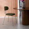 A green chair next to a wooden table with a vase of flowers. Anteprima dell’immagine prodotto
