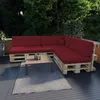 An outdoor seating area with a sectional sofa made of pallets and dark red cushions, a coffee table, and a rug. Voir les images du produit