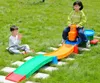 Two children playing with a plastic slide and car toy in a grassy yard. Voir les images du produit