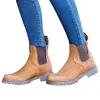 A pair of brown leather boots worn by a person wearing blue jeans, shown against a white background. Voir les images du produit