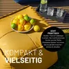 A yellow ottoman with a bowl of lemons and limes on it, with a tray of drinks in the background. Produktbild-Vorschau