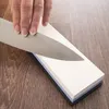 A hand is sharpening a knife on a whetstone. Produktbild-Vorschau