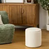 A cozy living room scene with a green armchair, a wooden cabinet, and a white ottoman. Náhled obrázku produktu