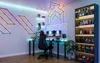 A modern gaming room setup with a desk, chair, and shelves filled with collectibles, illuminated by colorful LED lights. Anteprima dell’immagine prodotto