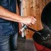 A person is spraying a cleaning product onto a grill. Produktbild-Vorschau