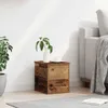 A wooden storage box with a vase and a cup on top, next to a sofa. Anteprima dell’immagine prodotto